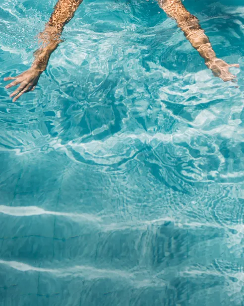 Hände im Wasser im Schwimmbecken des Mirador